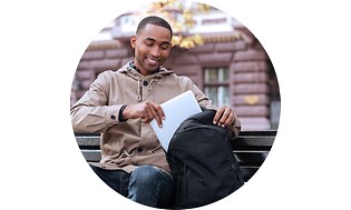 Ung mand der pakker sin laptop ned i en rygsæk