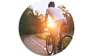 Mand der cykler på sin cykel ved solnedgang
