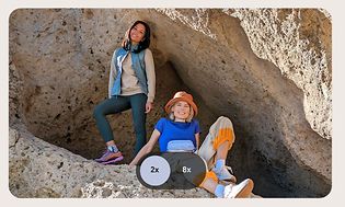 Two women at a cave photographed with high resolution zoom