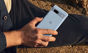 Man holding a Google Pixel 7a on a beach