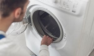 Man der tjekker gummilisten på en vaskemaskine