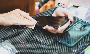 Person der rengør en smartphone med en klud