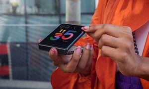 Motorola Razr halvt sammenfoldet i hænderne op en kvinde i orange
