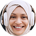 Ung kvinde der bærer høretelefoner udover sin hijab og smiler til kameraet