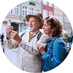 Ældre par, der står på gaden og tager billede med deres smartphone