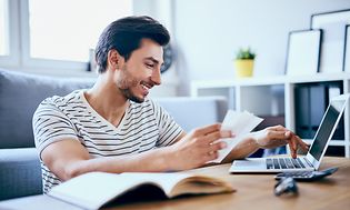 En mand, der betaler sin regning på sin computer