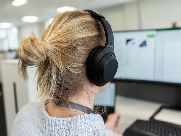 Woman with headphones looking at screen