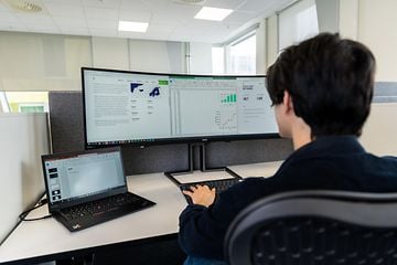 B2B - Computing - Bigger monitor - Office employee working with ultra-wide screen