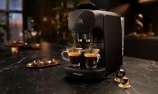 Lor Sublime kaffemaskine med kaffekapsler rundt om