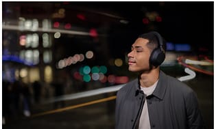 Mand med Sony støjreducerende hovedtelefoner i mørke