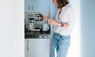 Kvinde i et køkken laver kaffe