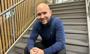 Mig-tid - Ambassadør Christian i blå Elgiganten-skjorte på en trappe