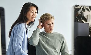 Mand og kvinde ser på en computerskærm på et kontor