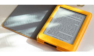 Kobo e-bogslæser med gult etui på et bord