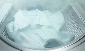 En hvid skjorte der bliver dampet inde i en Electrolux-vaskemaskine