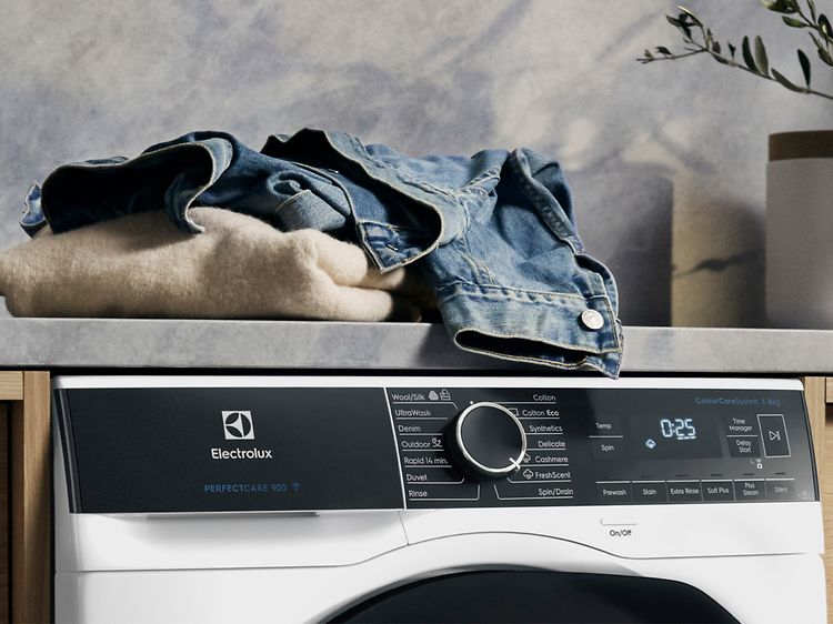 Electrolux vaskemaskine med tøj på toppen, der er klar til at blive vasket