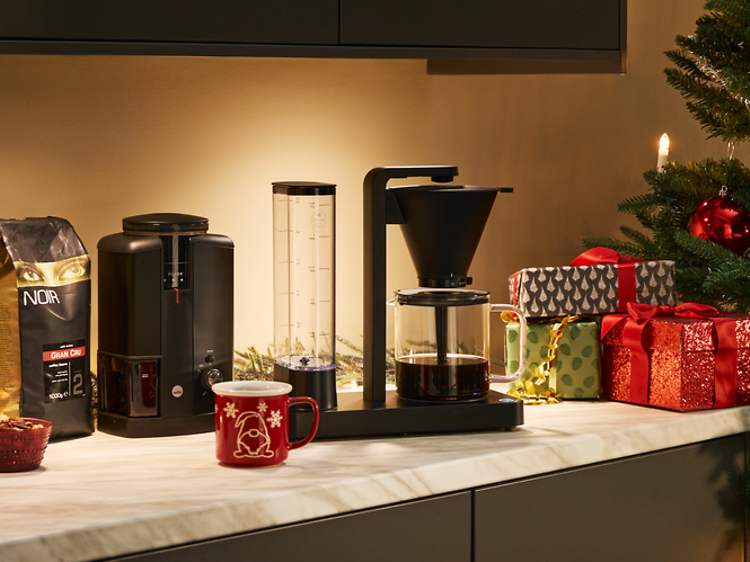 Kaffemaskine og kværn på et køkkenbord ved siden af julegaver og dekorationer - desktop