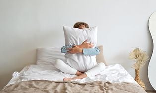 Luftkvalitet - kvinde i en seng der krammer en pude
