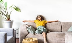 Luftkvalitet - Kvinde i en sofa i en stue med grøn plante