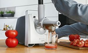 Person laver friskpresset tomatjuice med frugtpresser på Bosch kødhakker