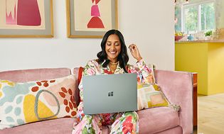 En kvinde i et farverigt rum med Microsoft Surface Laptop 5