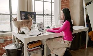 Kvinde arbejder på computer ved skrivebordet