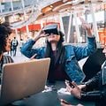 Flere kvinder kigger på en anden kvinde, der har VR-headset på