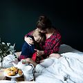 Kvinde overraskes med morgenmad på sengen og krammer sit barn
