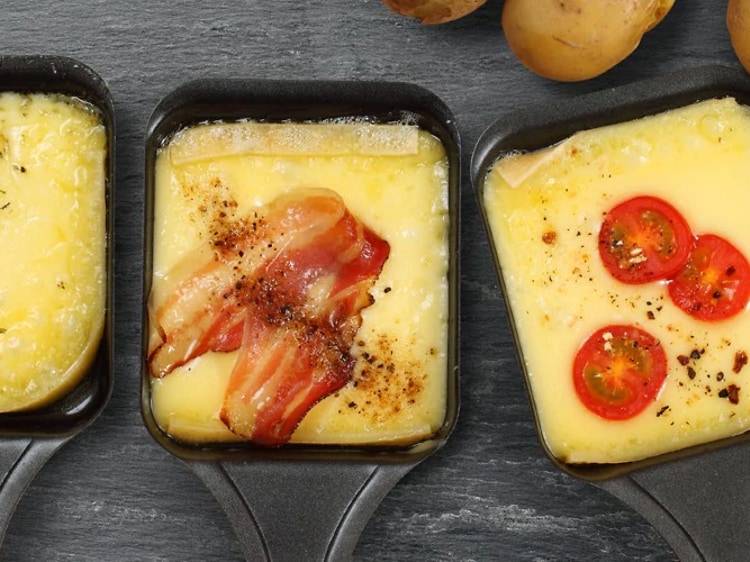 Tre raclette-pander med ost og topping