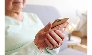 Ældre dame med en smartphone i sin hånd