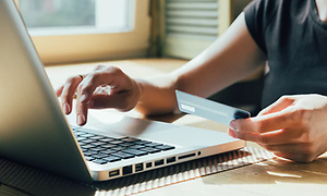 Mand der betaler med kort på en computer