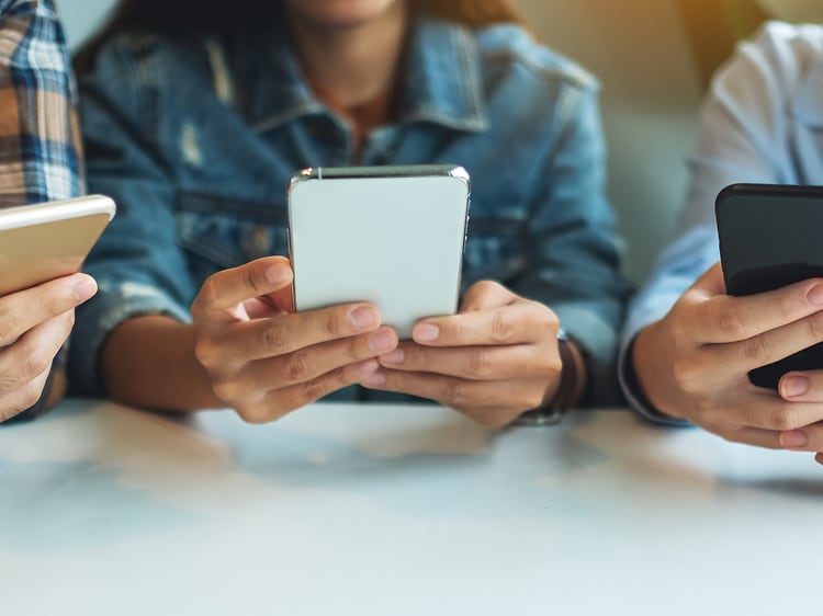 Tre unge der bruger deres smartphones