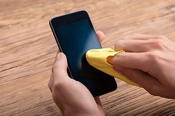 Rensning af en telefon med gul klud