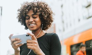 Pige der kigger på en telefon med headset i