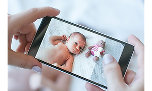 Person der tager et billede af en baby og en dukke