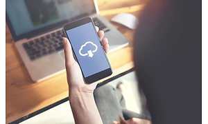 Kvinde med et billede af en cloud-tjeneste på sin telefon