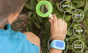 Dreng der undersøger naturen med et forstørrelsesglas og et smartwatch