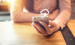Kvinde der holder en telefon med et cloud logo på