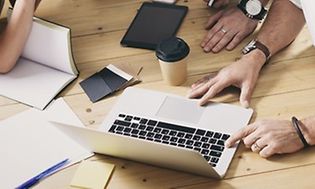 tre mennesker der arbejder sammen i et møde