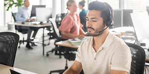 mand på et åbent kontor med sit headset