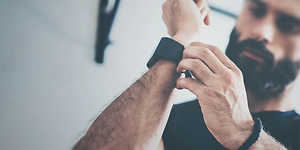 Mand strammer urrem til smartwatch omkring hans håndled