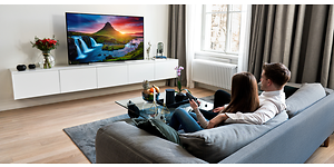 par sidder i en sofa og ser TV med stærke farver
