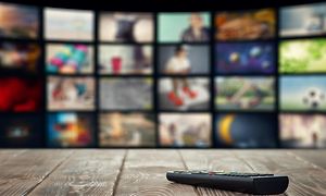 Fjernbetjening på et træbord foran TV