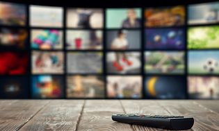 Fjernbetjening på et træbord foran TV