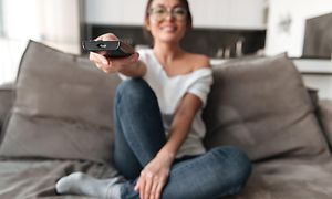 Kvinde i sofa med fjernbetjening