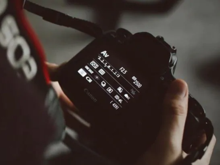 nærbillede af en fotograf der justerer på sit kameras indstillinger