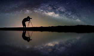 Profil af mand med kamera i horisonten med stjernehimlen i baggrunden