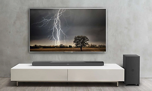 Stort TV med et billede af et lyn. Under og ved siden er af en soundbar