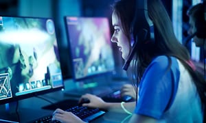 Pige der spiller computer med et gaming headset