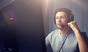 Mand der sidder foran sin computer med et gaming headset